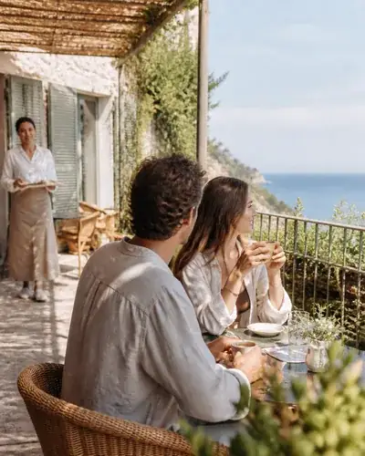 Parella gaudint d'un matí mediterrani a la terrassa d'un hotel boutique