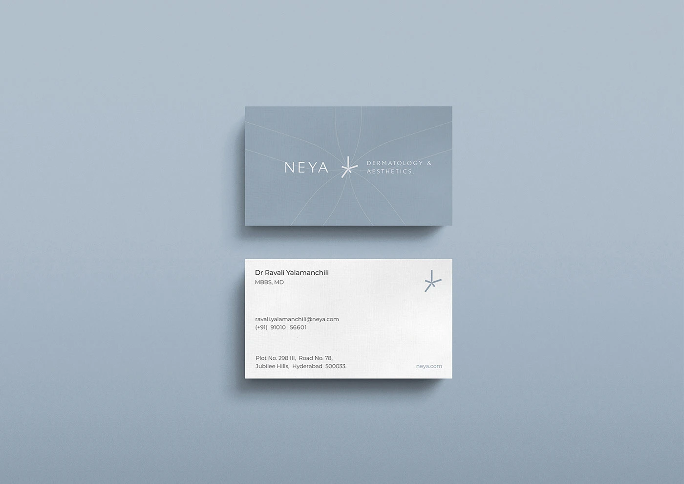 Two Neya cards with a shared symbol and composition on a blue-grey background