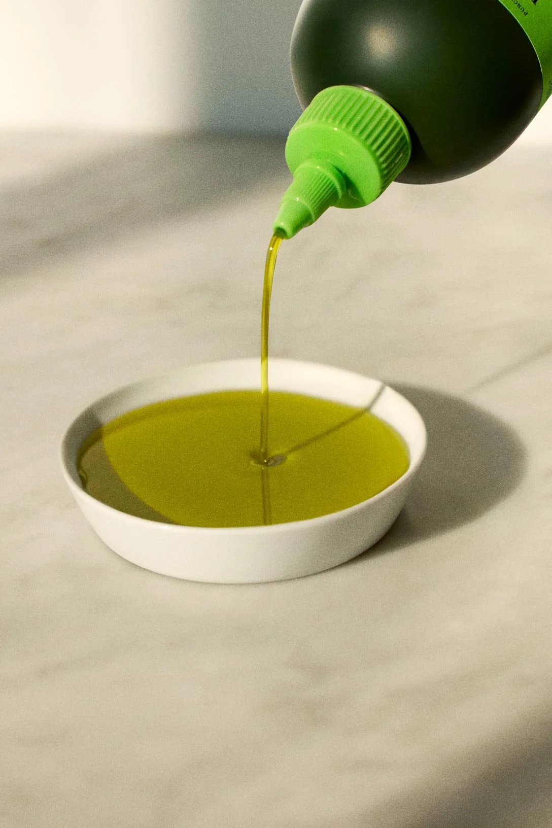Graza oil being poured from a cooking bottle in a photograph by Anisha Sisodia