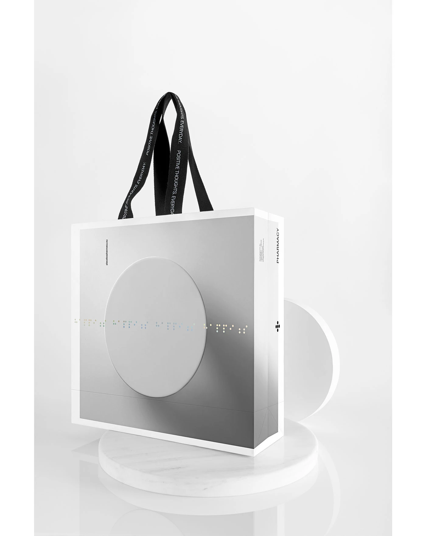 Bossa blanca de Placebo Pharmacy amb un cercle en relleu i detalls d'identitat de Luminous Design